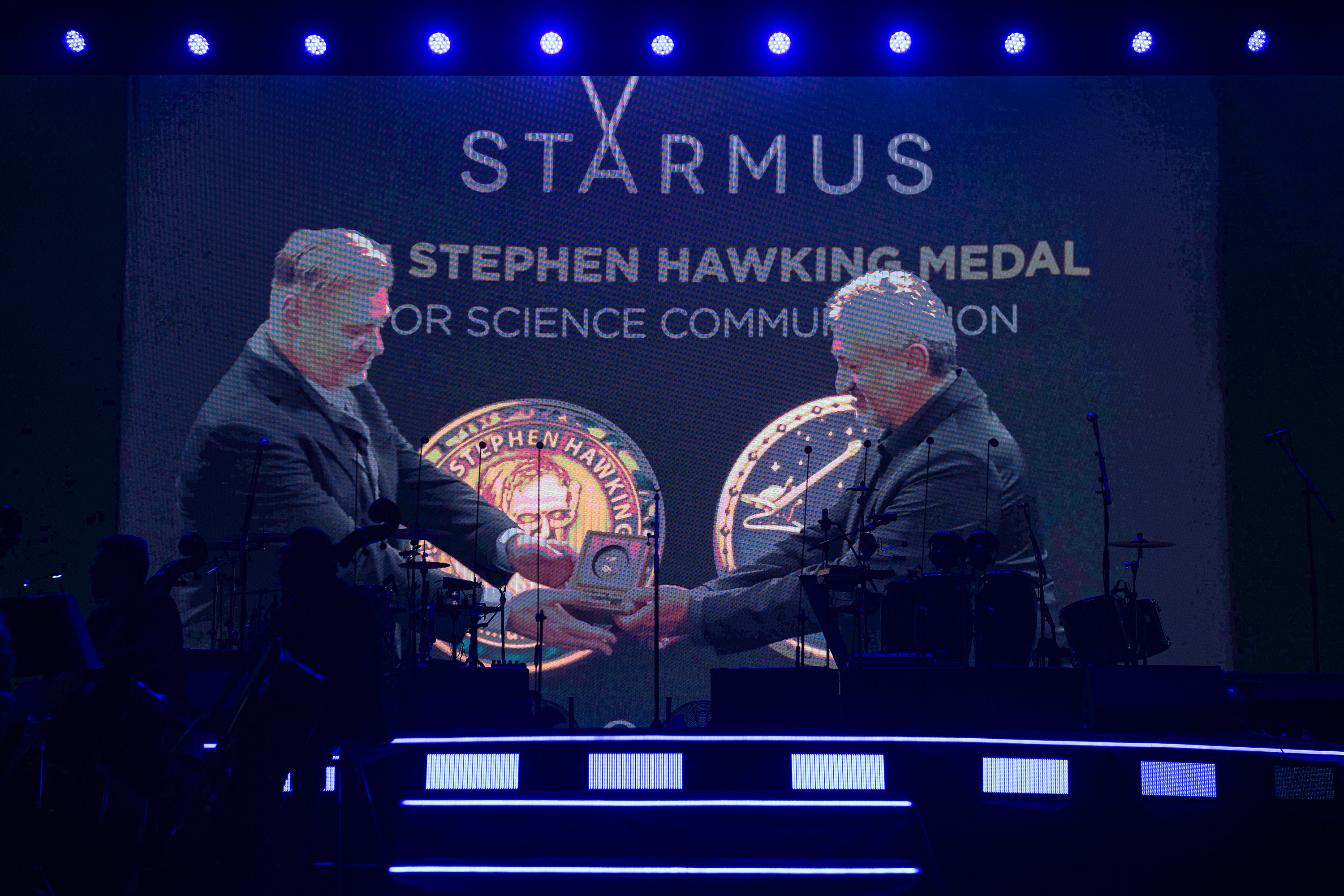 a person in a suit receives an award onstage