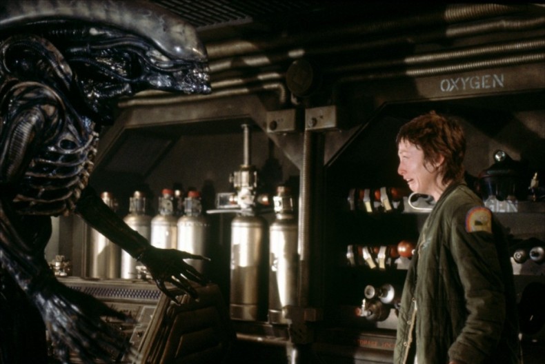 an alien monster prepares to eat a female crew member