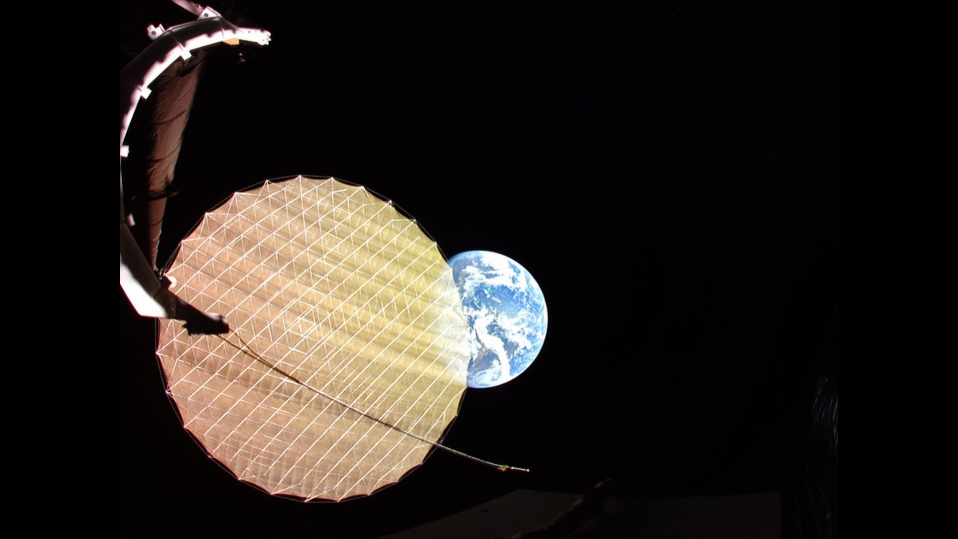 Earth photobombs a satellite deploying its giant reflector | Space photo of the day for May 14, 2026